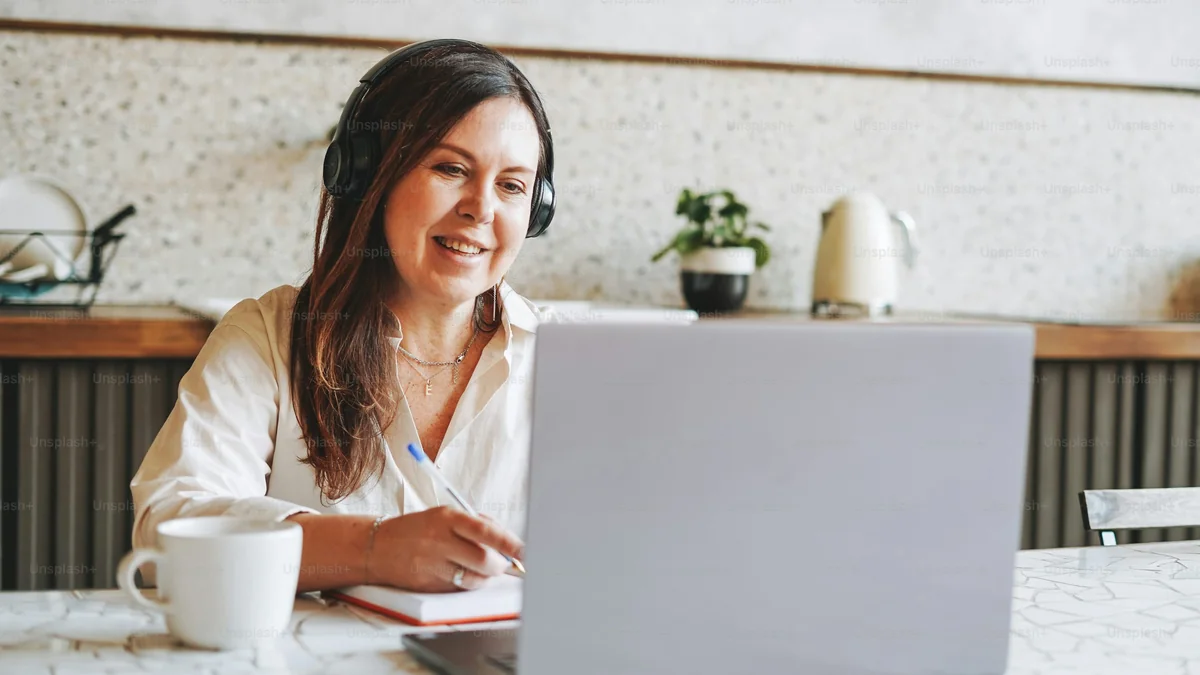Femme suivant une formation en ligne avec un casque audio - illustration de l'article Comment choisir une formation en thérapie holistique et coaching