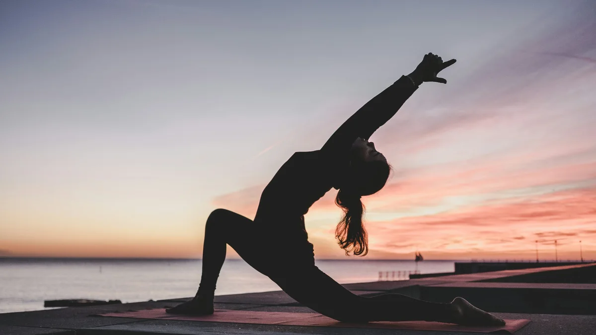 Posture de yoga au lever du soleil - illustration de l'article Pleine conscience et méditation : guide complet MBSR et thérapie holistique
